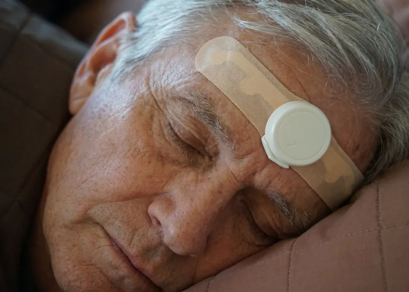 Iemand die slaapt met de JawSense ONE-sensor boven één wenkbrauw