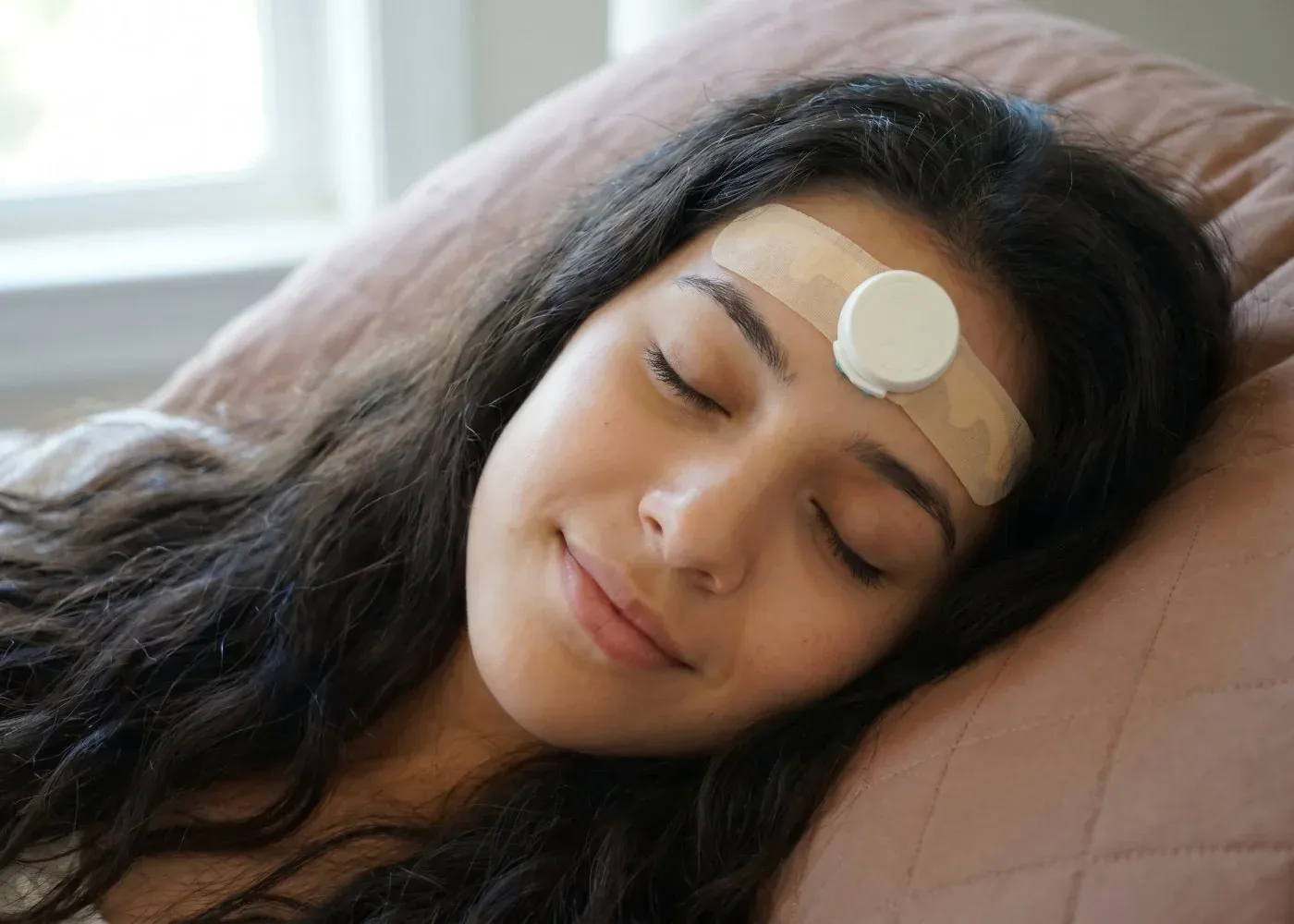 Asleep at home wearing the JawSense ONE sensor on the forehead